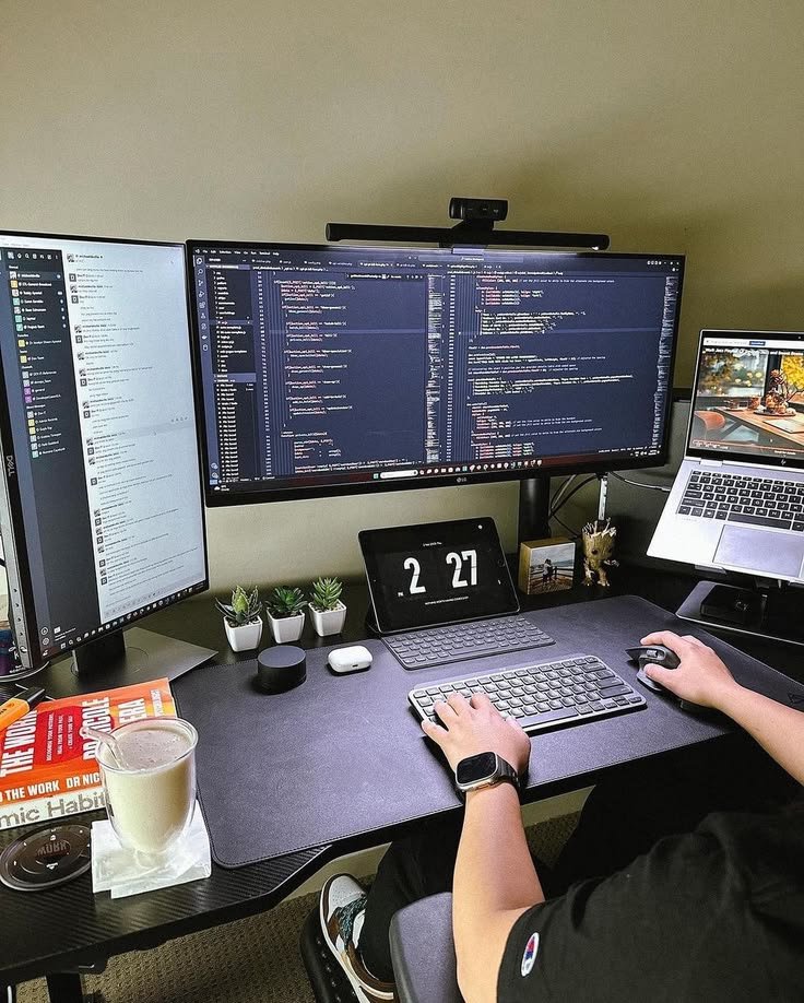 A website developer building an author website across a professional multi-screen workspace